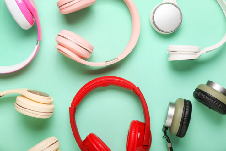 Different headphones on color background